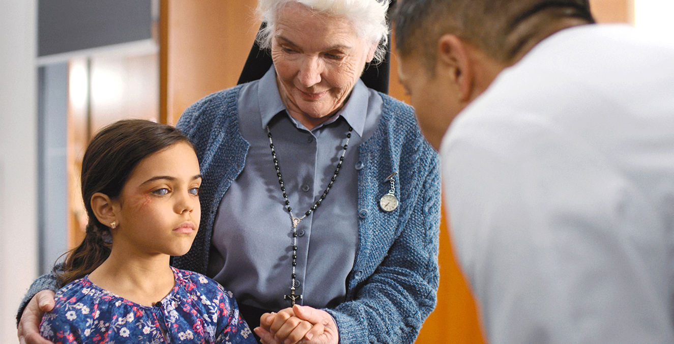 A visually impaired girl is accompanied by an older woman.