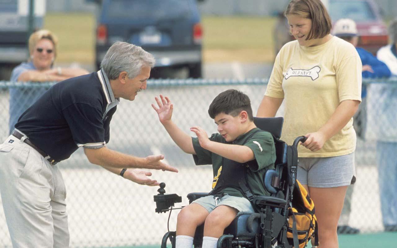 A supporter congratulates a Miracle League player and his “buddy.” (Courtesy The Miracle League)