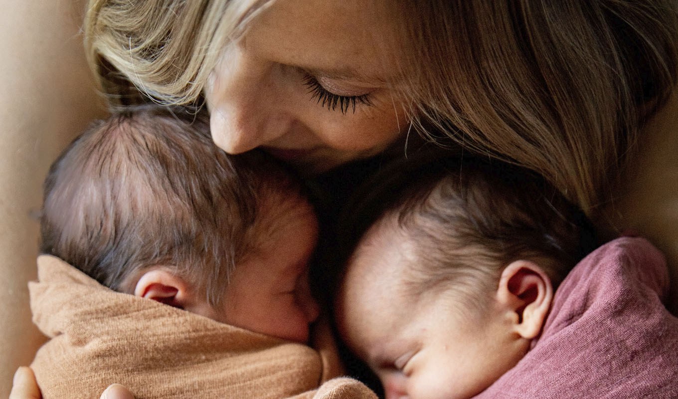 Mom holds newborn twins.