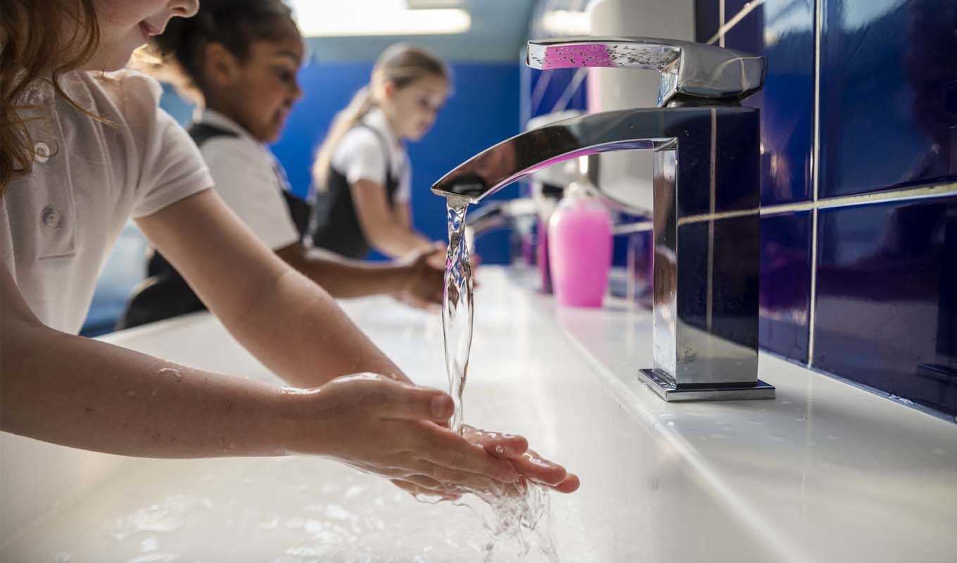 Elementary school kids washing their hands in a bathroom