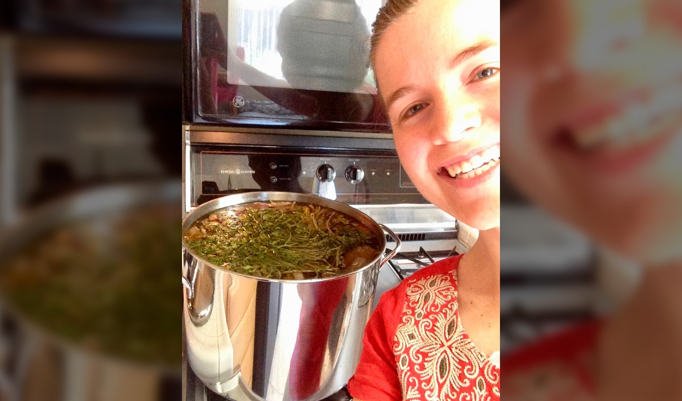 Andie Dill cooking some broth on the stove