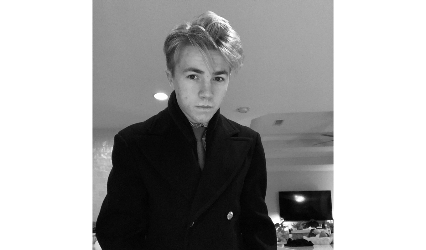 A young man showcases a fresh style with a modern haircut and trendy outfit, reflecting his evolving fashion sense.