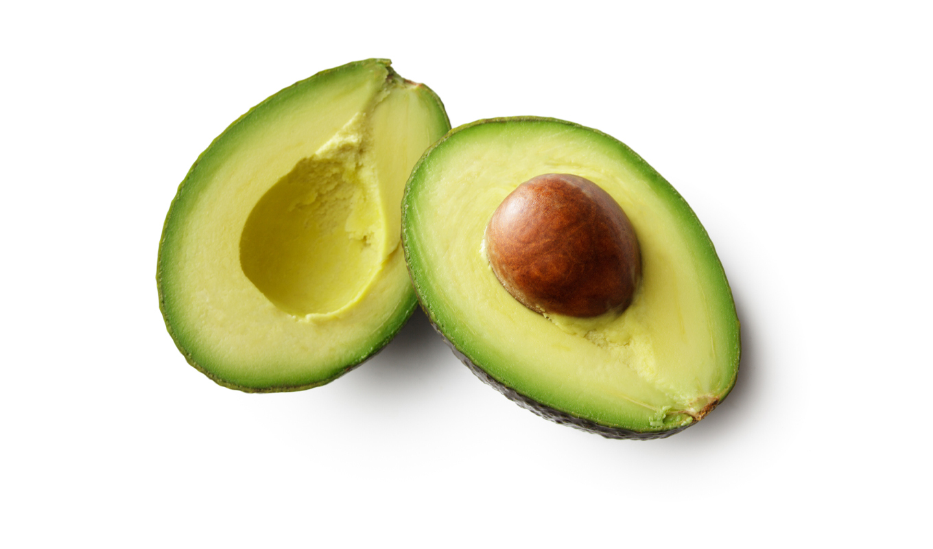 An avocado with its pit is shown sliced.