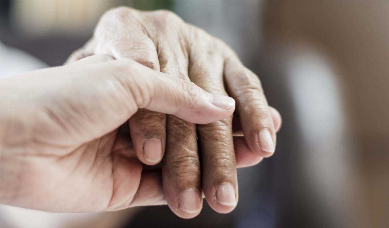 Elderly couple holding hands