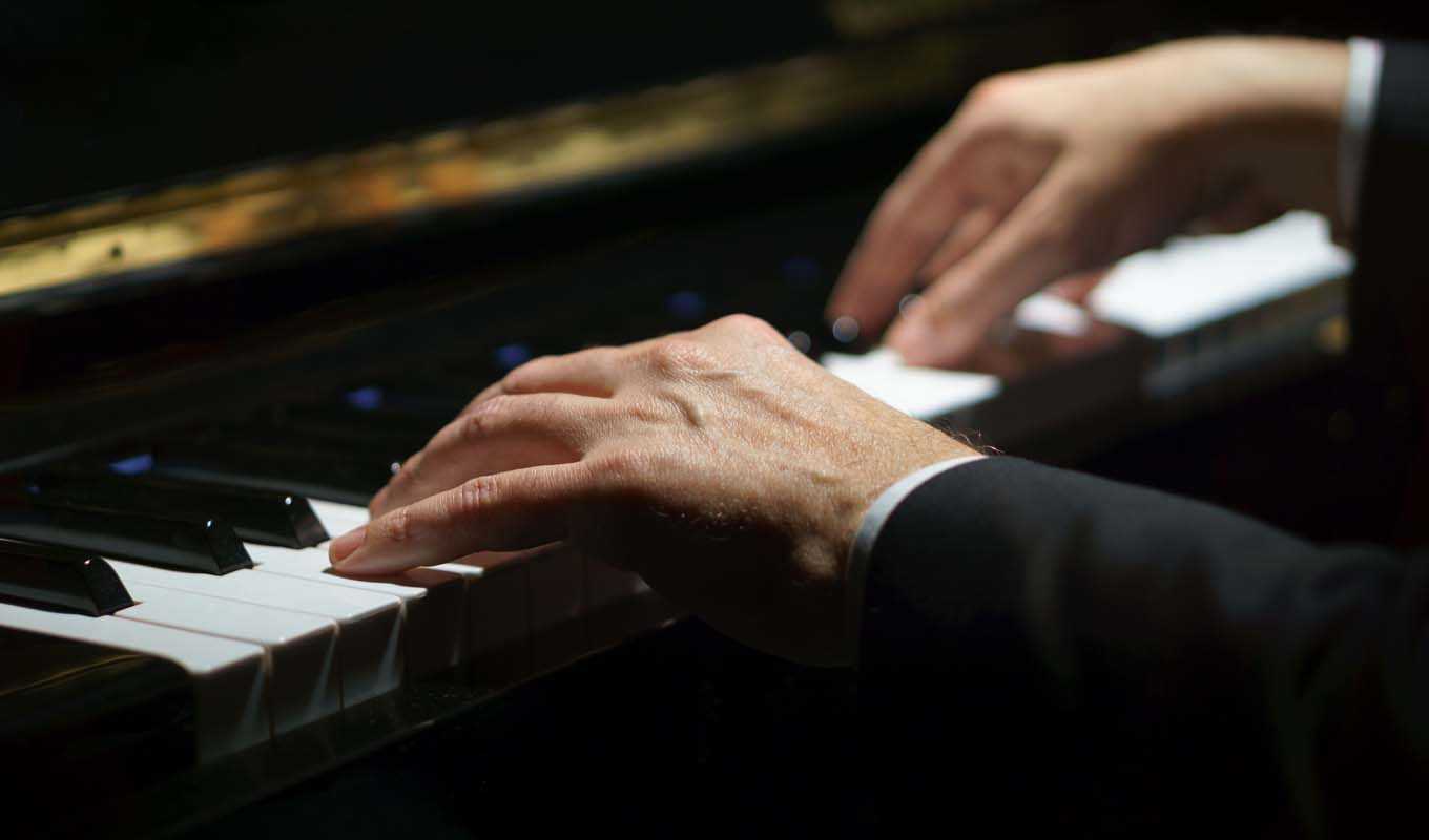Closeup on hands that are playing a piano