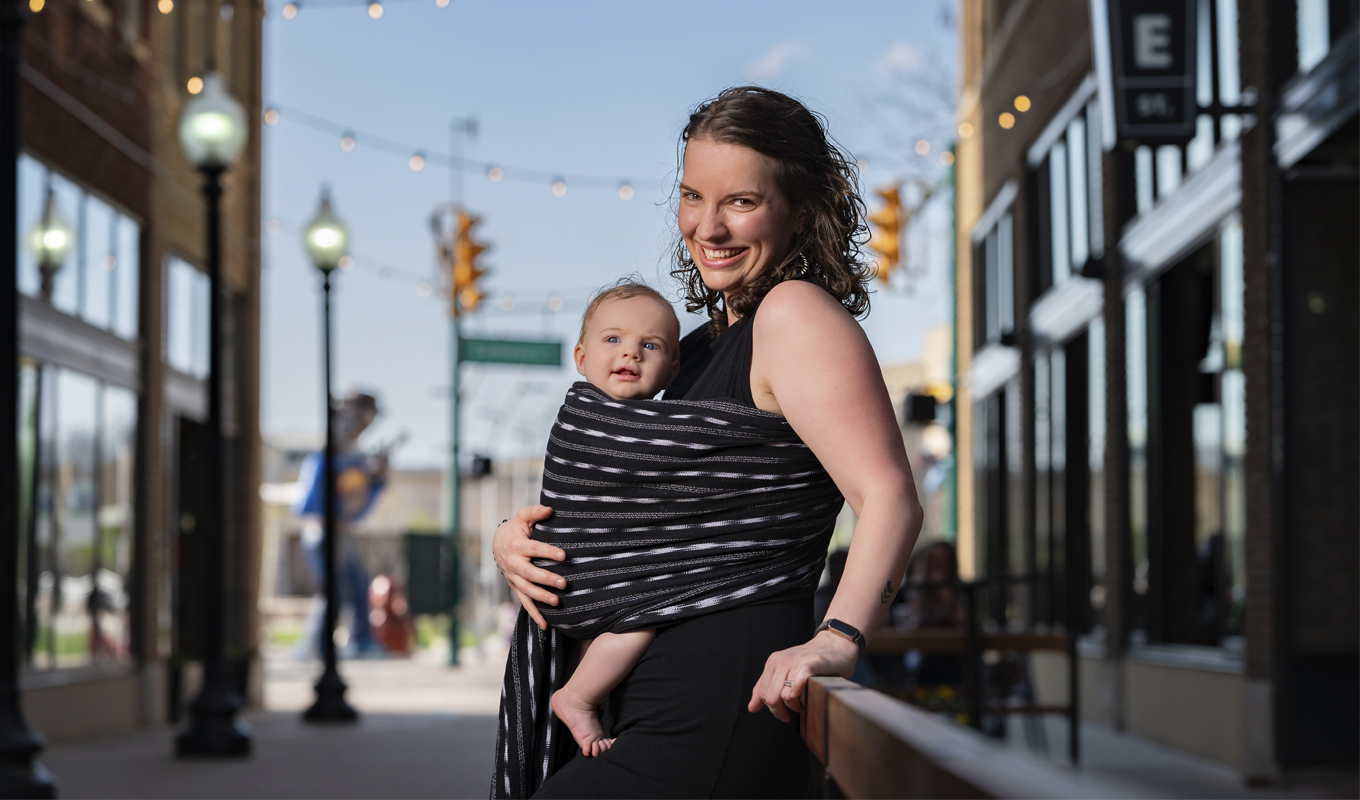 Danielle Ellis posing with her infant.