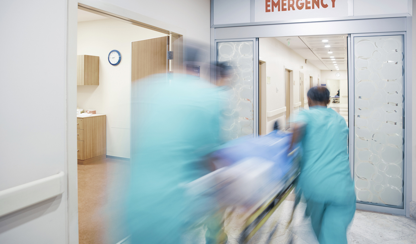 hospital personnel rushing gurney in emergency room