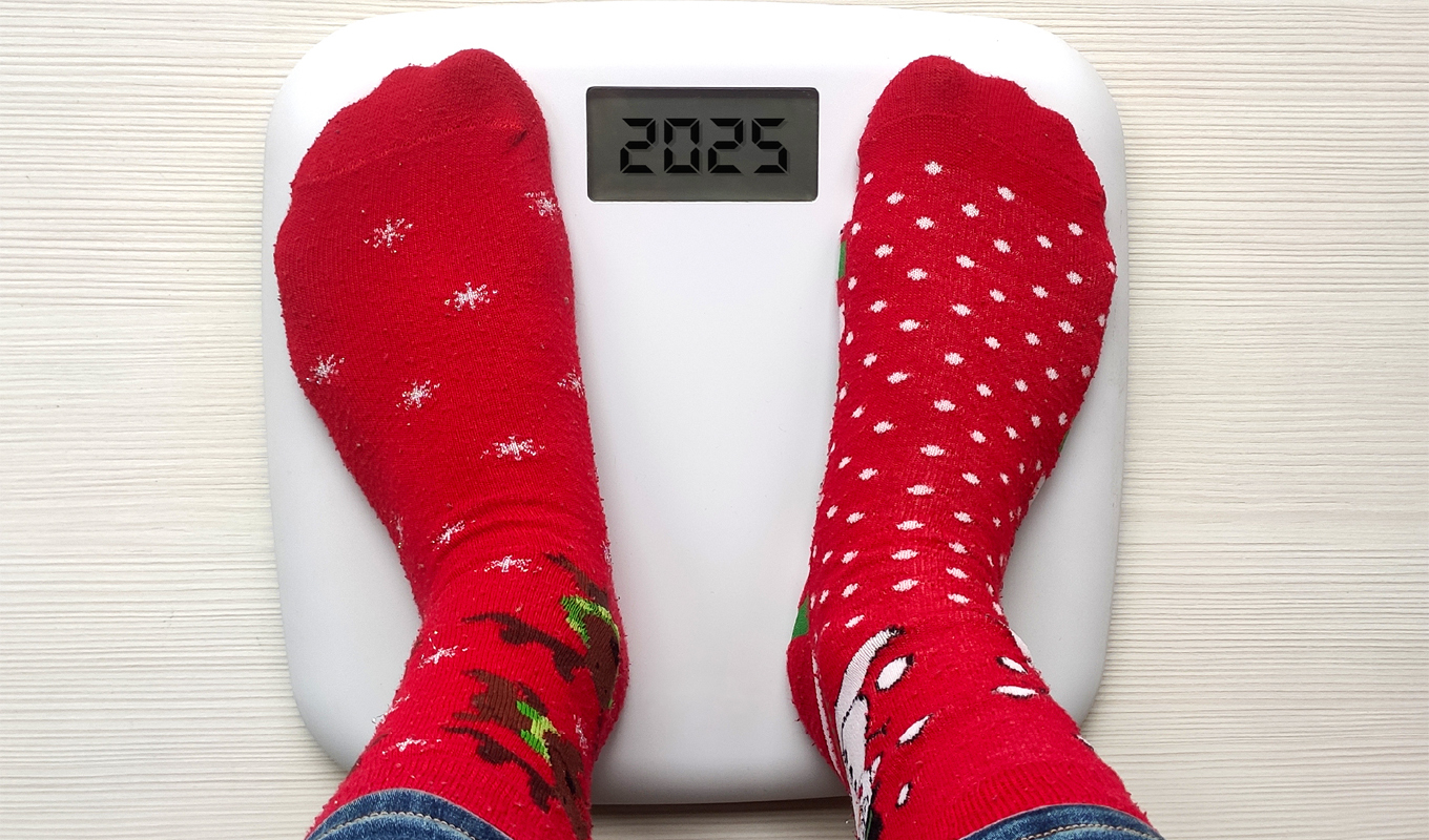 A person stands on a scale, showcasing bright red socks that add a pop of color to the scene.