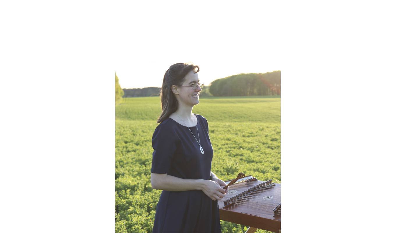A serene landscape featuring rolling hills, a clear blue sky, and a hammered dulcimer