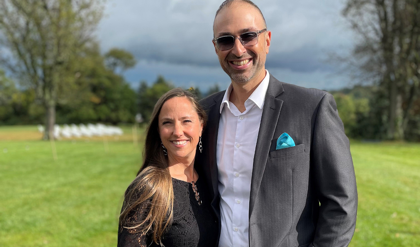 A couple standing in a grassy field