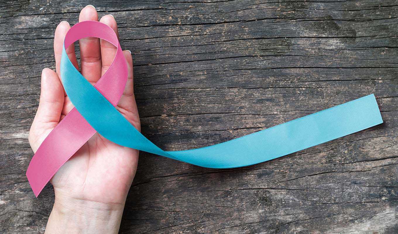 Woman's hand holding a miscarriage ribbon