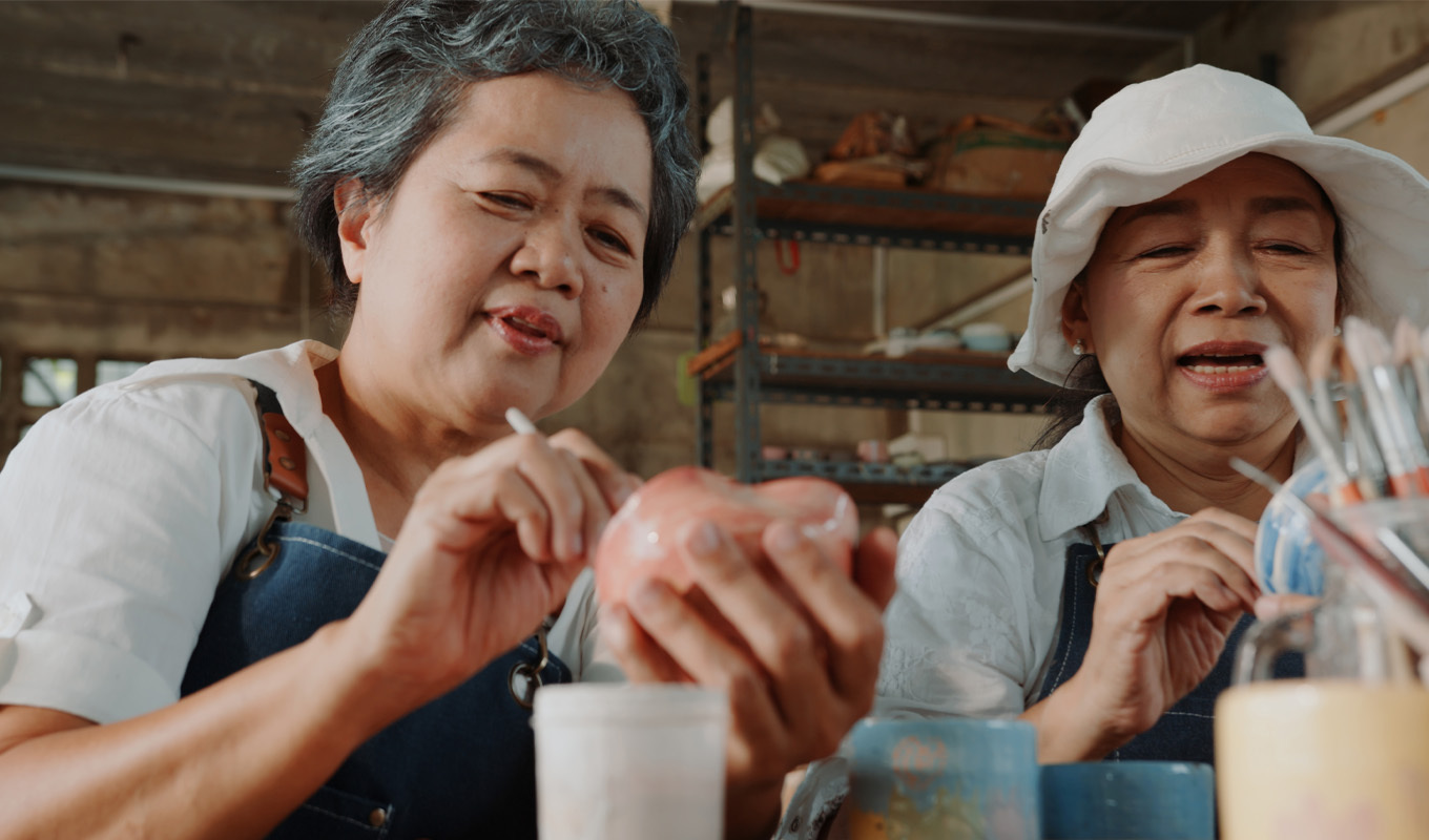 Two women work on crafts together.