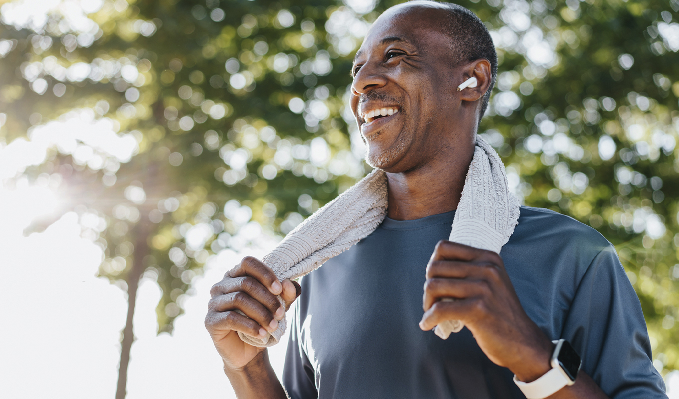 Man with towel wrapped around the back of his neck.