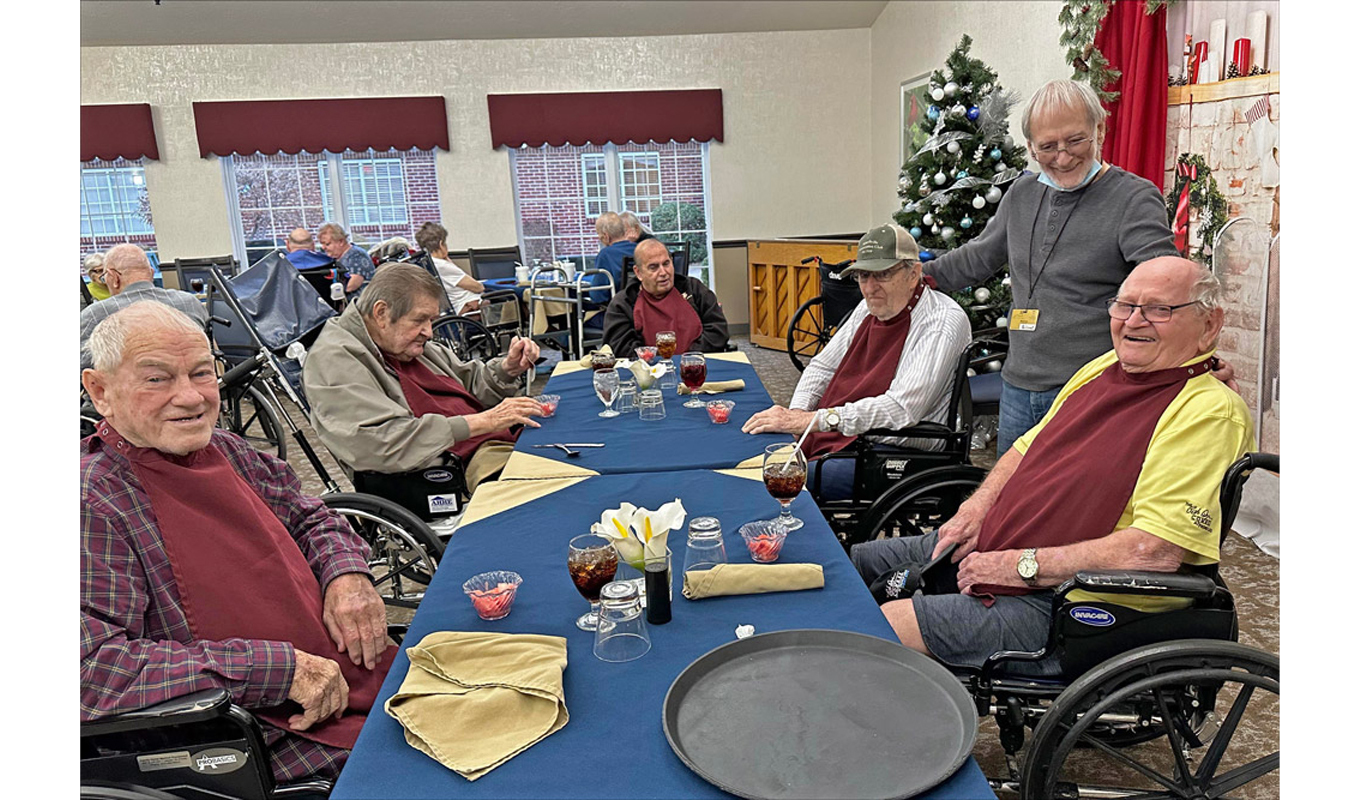Volunteer Warren Staples, standing at right, visits residents of a nursing home in Jasper, Indiana. Warren signed up after he saw the many needs of those living there.