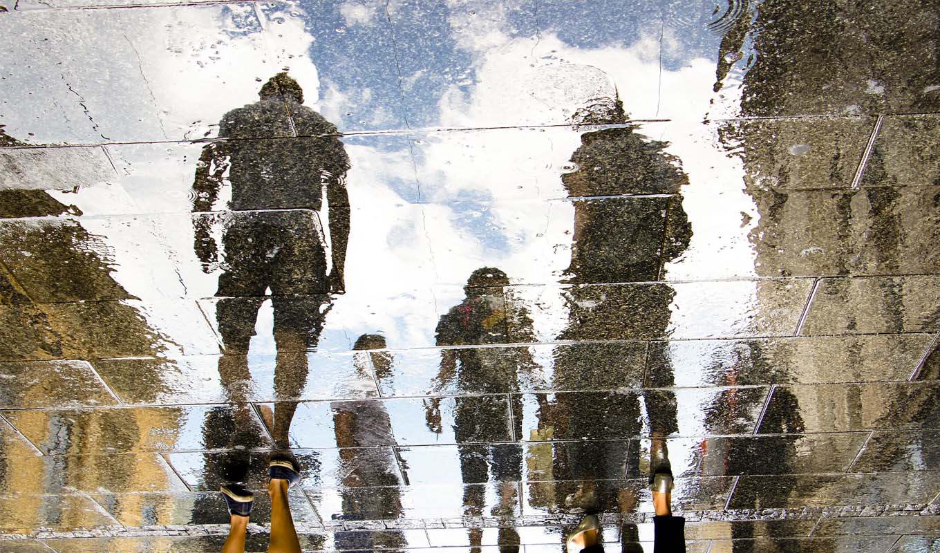 People's reflections on a wet walkway