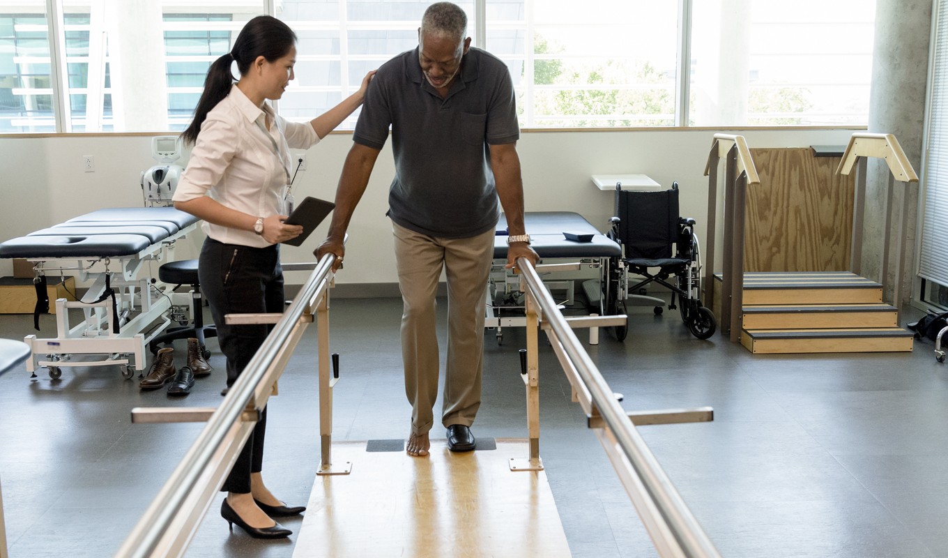 Man working with a nurse through physical training