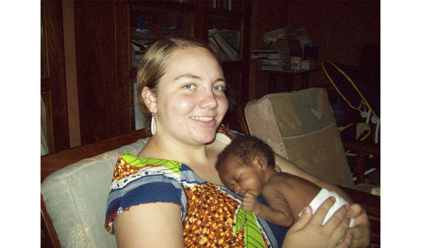 A woman embraces a baby in her arms,