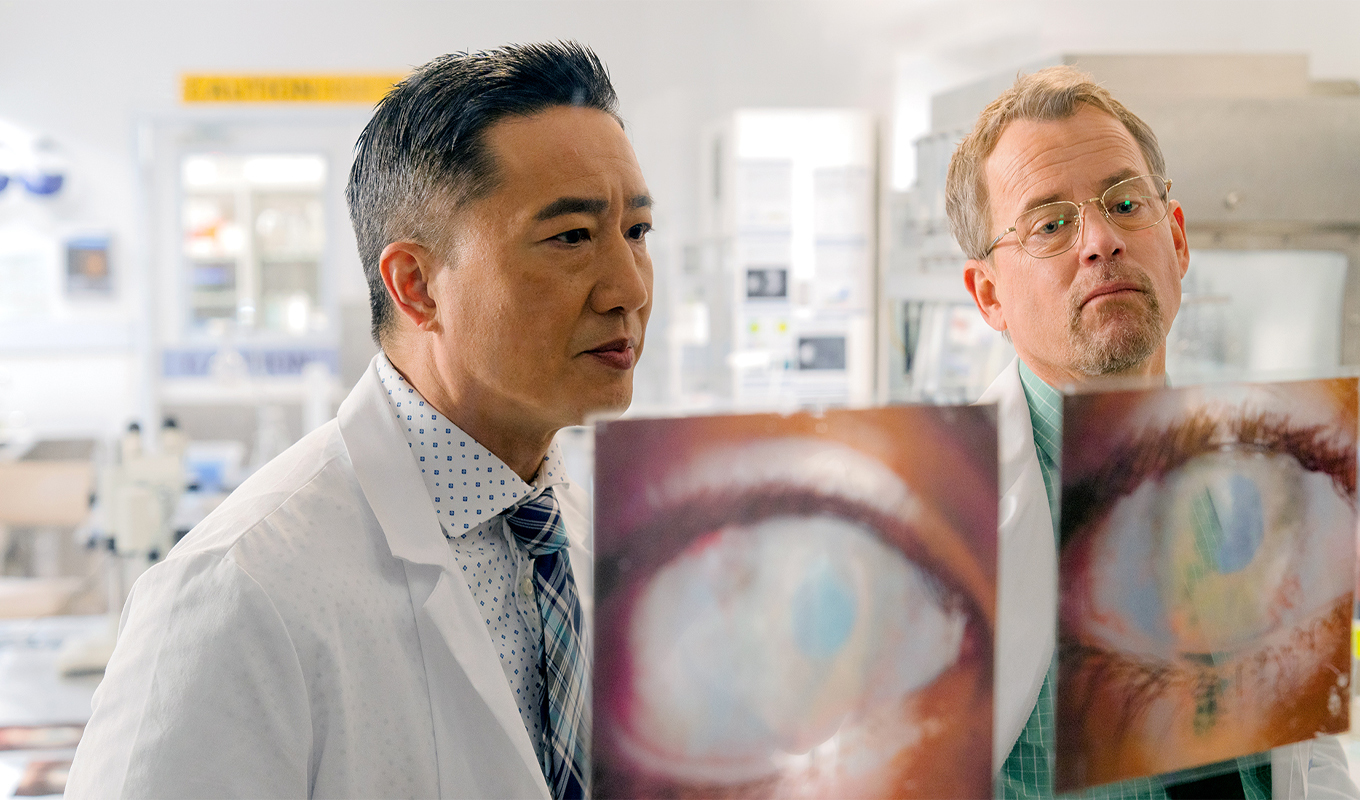 Two doctors look at images of eye scans.