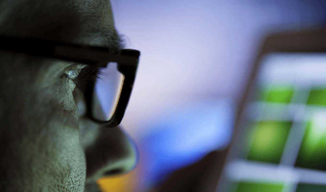 Closeup of a man staring at several screens
