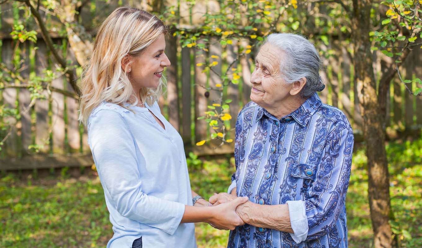 Elderly woman walking in a park with another woman