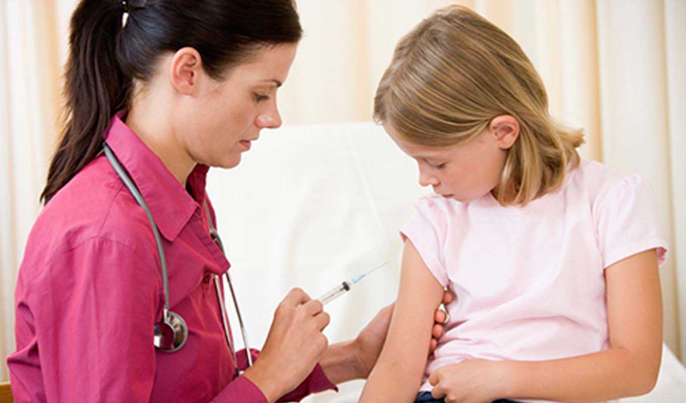 Doctor giving an adolescent girl a shot