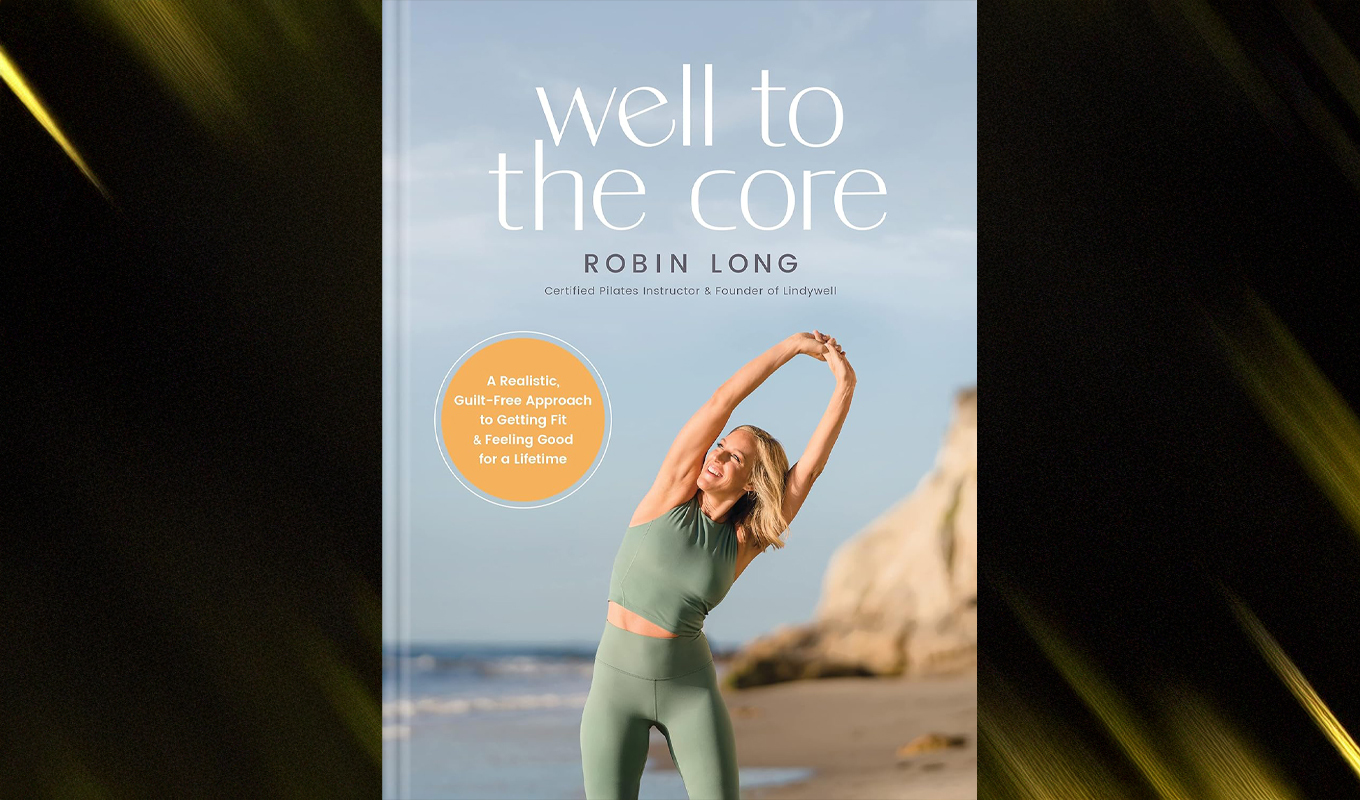 Book cover titled "Well to the Core" by Robin Long. The cover features a woman in athletic wear, smiling and stretching upward with her arms above her head, on a beach. The background includes the ocean, sky, and sand. Text on the cover states that the author is a certified Pilates instructor and Founder of Lindywell, also featuring a realistic, guilt-free approach to feeling good for a lifetime.
