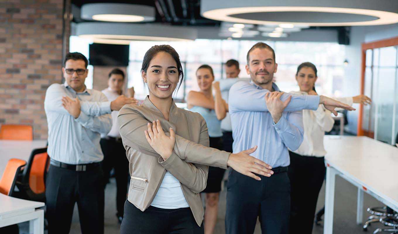 Coworkers stretching together in the office