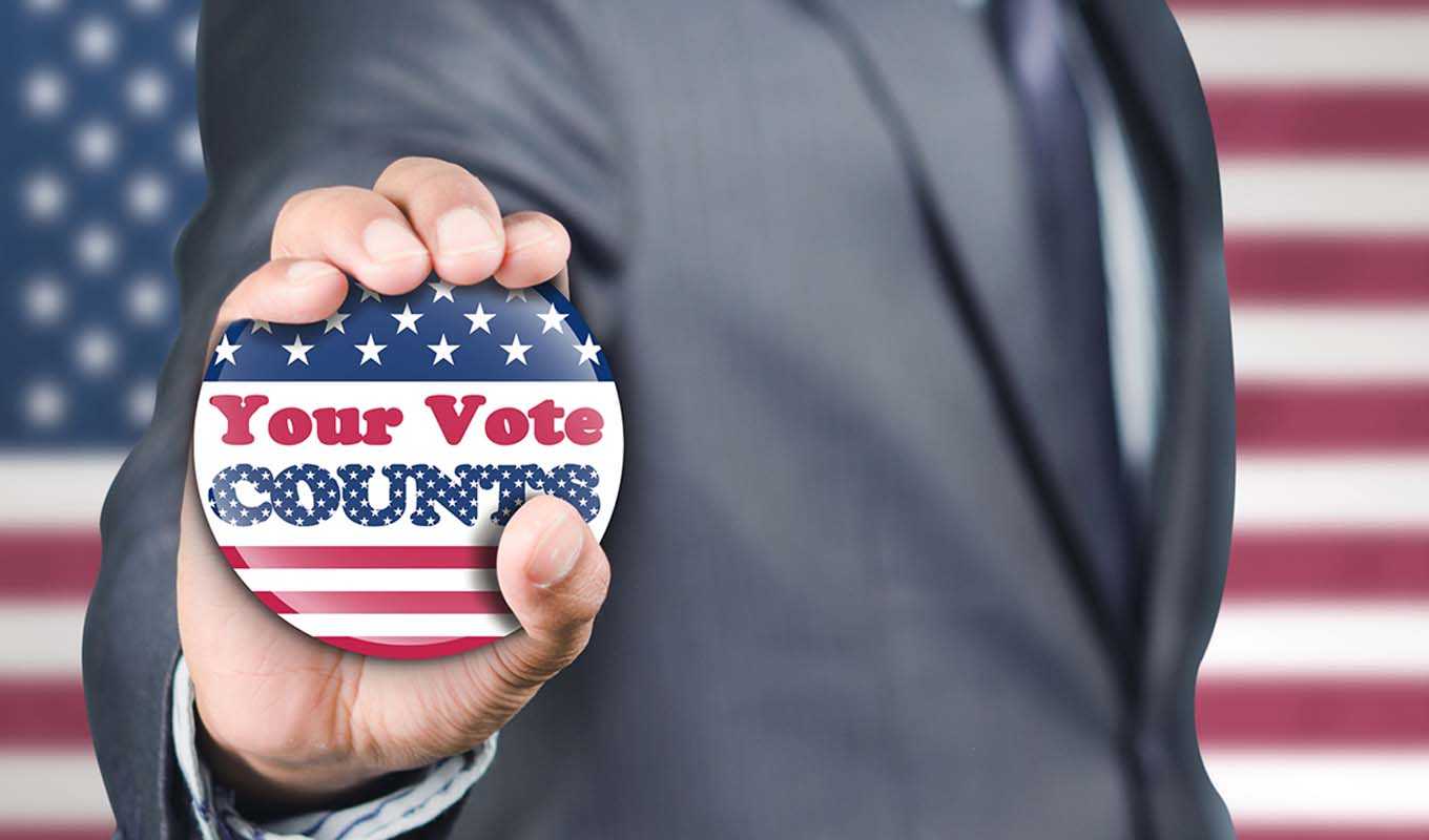 Man holding a "Your vote counts" button