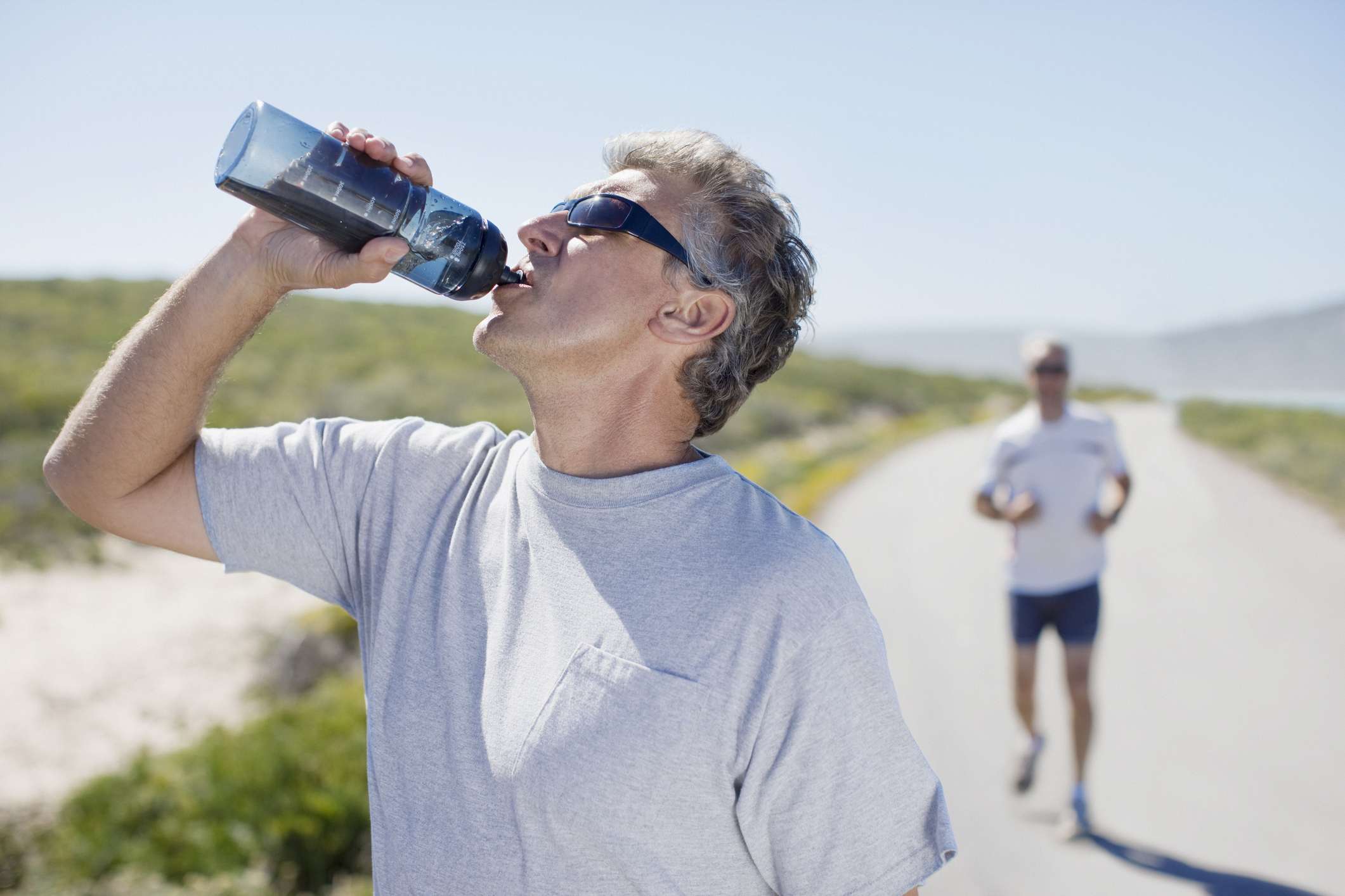 Running man drinking water