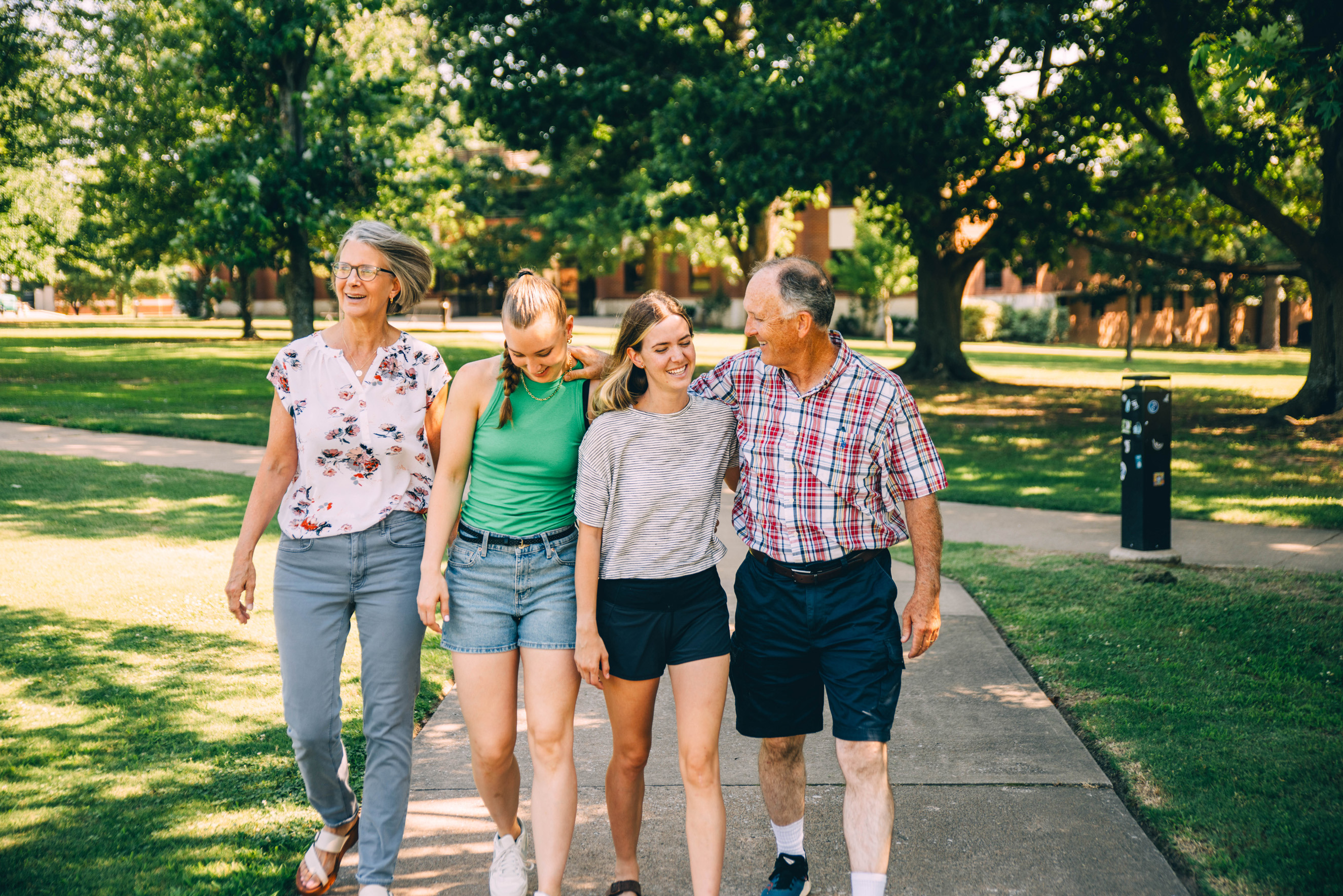 John and Michelle walking down a sidewalk with their two daughters.