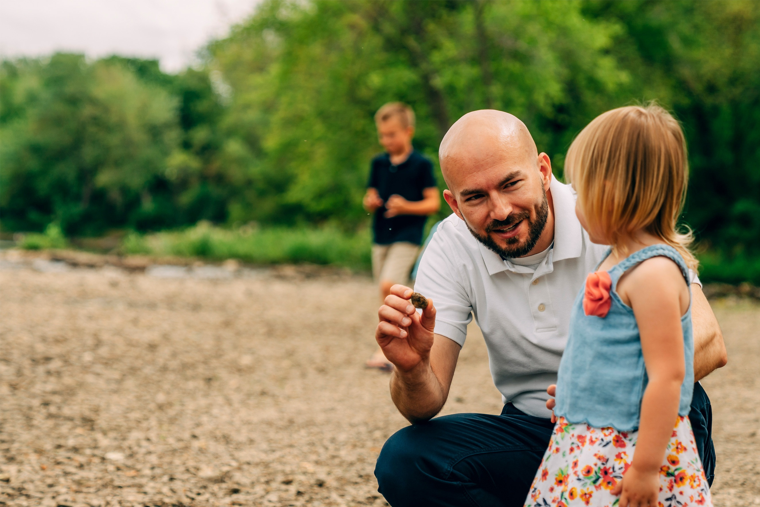 Kyle showing his daughter a rock from a dried up river bed.