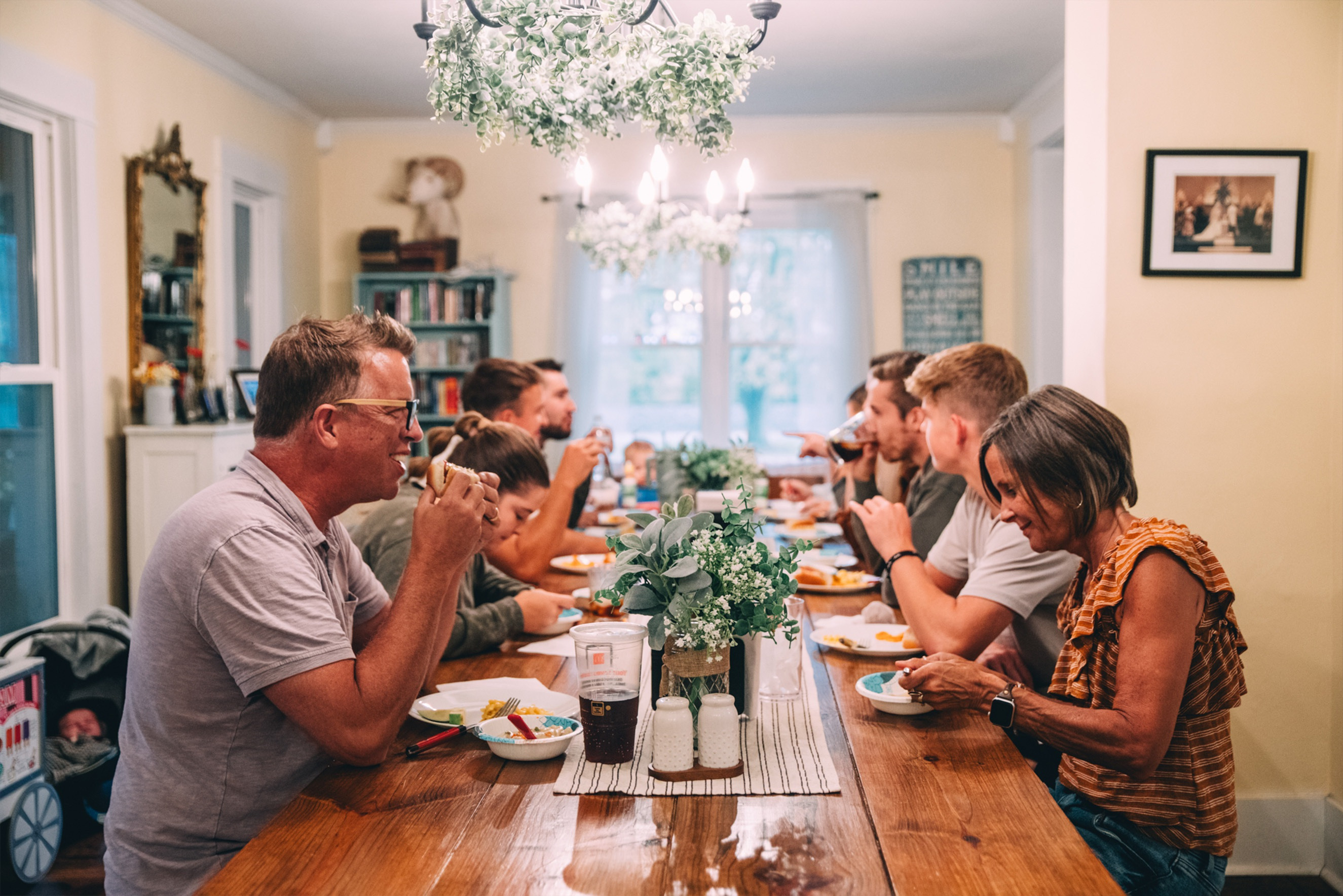 Todd, Debbie, and all their children sitting at the dining room table for a meal.